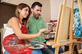 Couple drawing and painting on canvas, enjoying their creative time together.